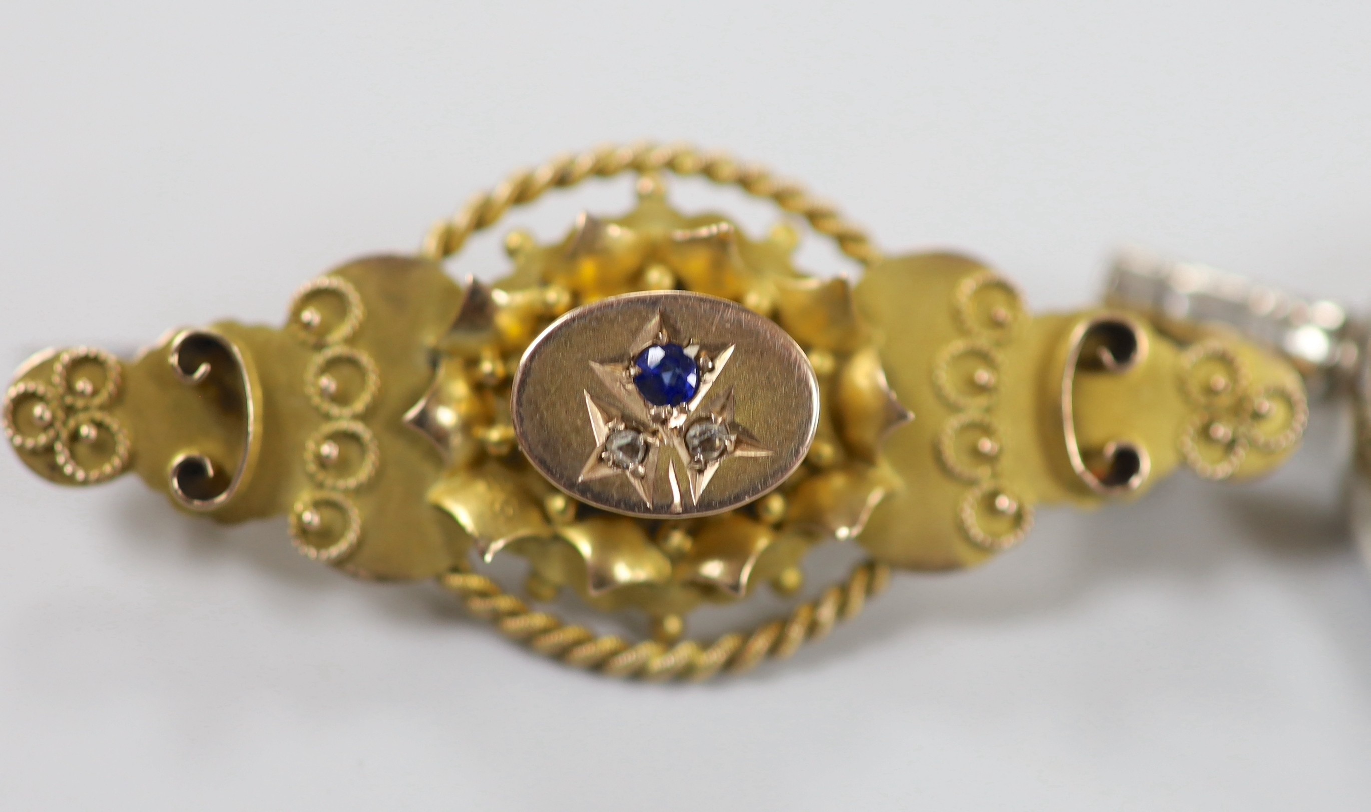 An Edwardian 9ct gold, sapphire and diamond chip set three stone brooch, 41mm, gross weight 33 grams and a bloodstone and carnelian set white metal spinning fob watch key.
